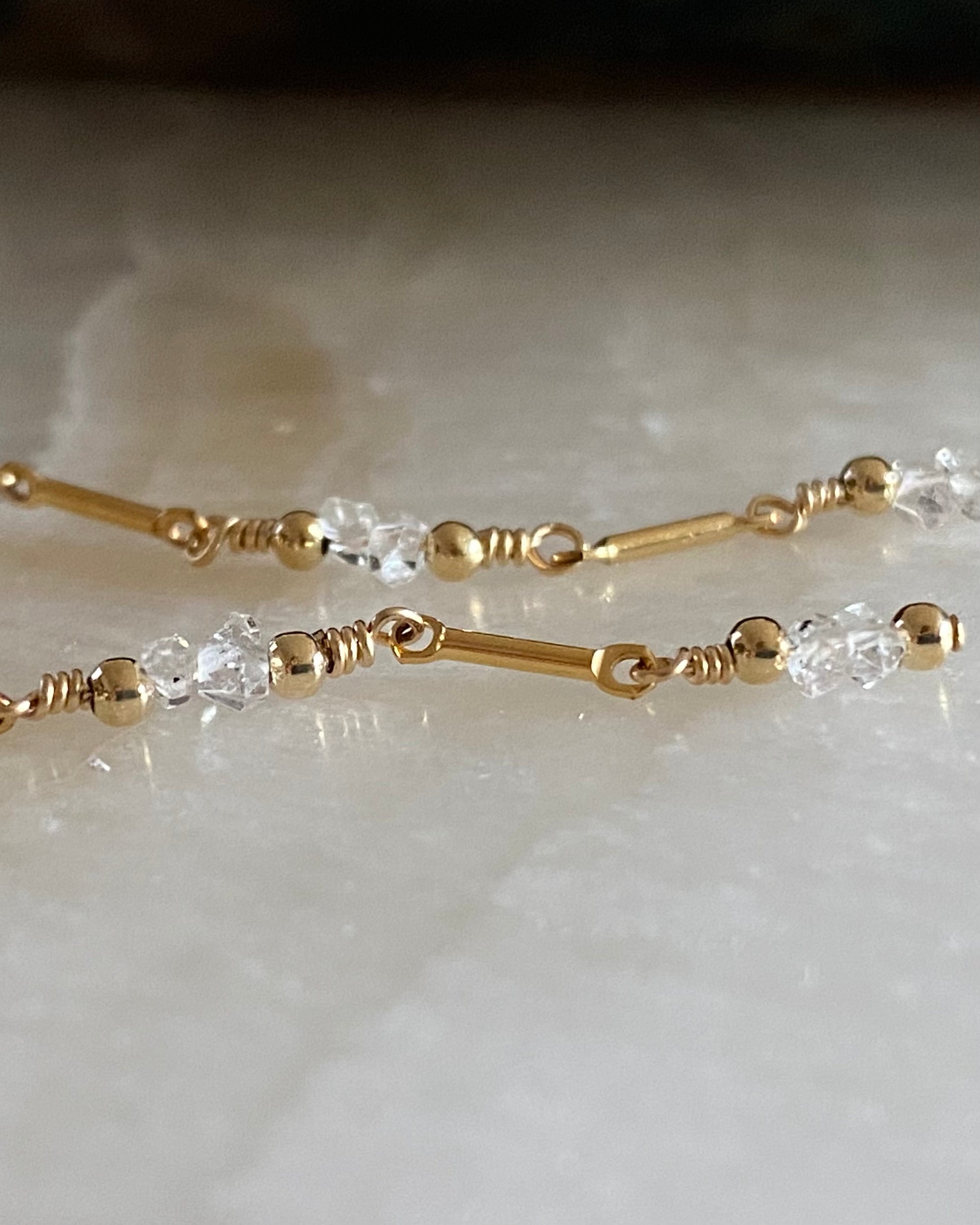 Close up of Gold and herkimer diamond thread earrings