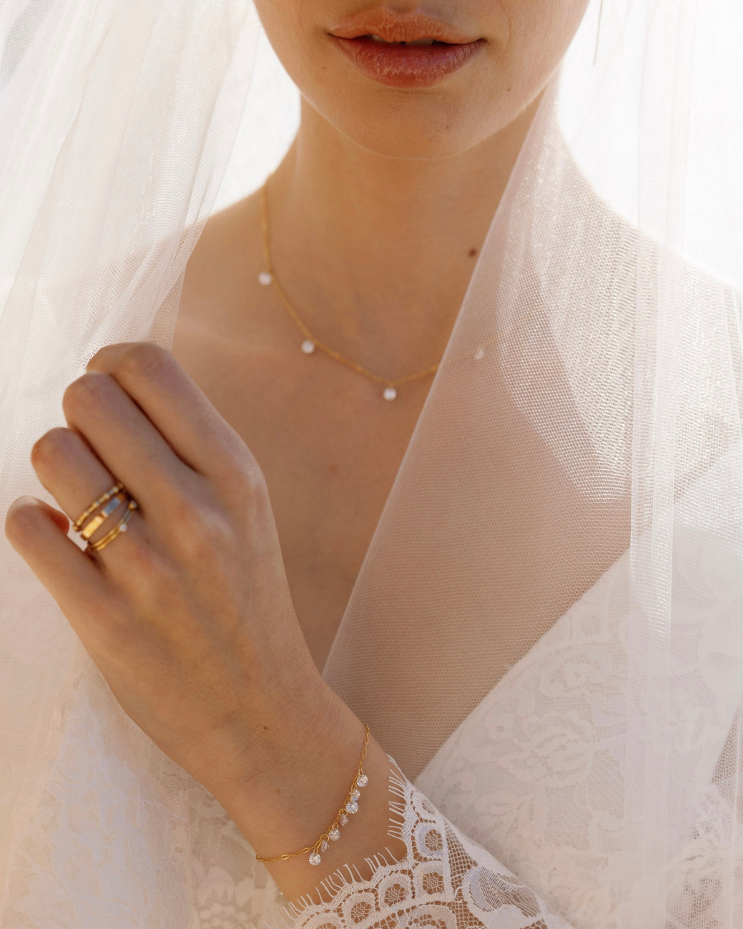 Close-up of a bride in veil wearing gold jewelry with cubic zirconia gemstones.