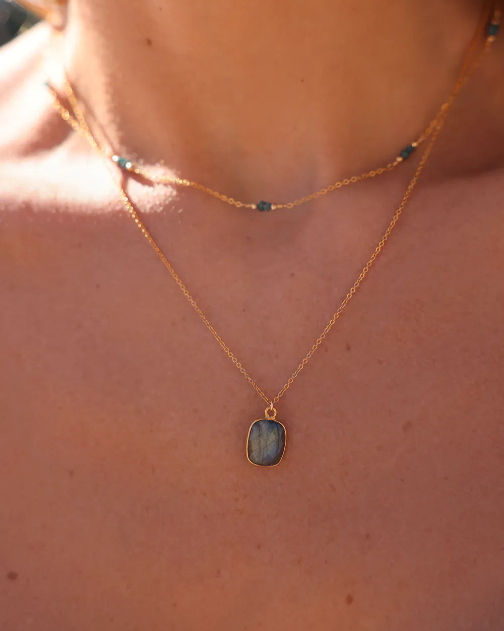 Model wearing Labradorite gemstone pendant, suspended from a delicate gold cable chain