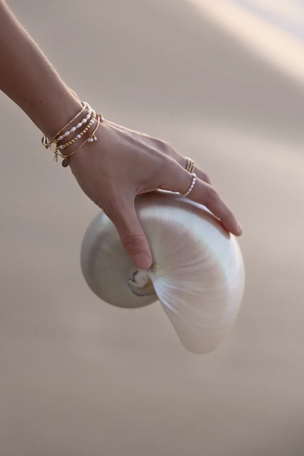 Hand with bracelet with a mix of round and sleek tube beads, it features tassels of beautiful freshwater Pearls.