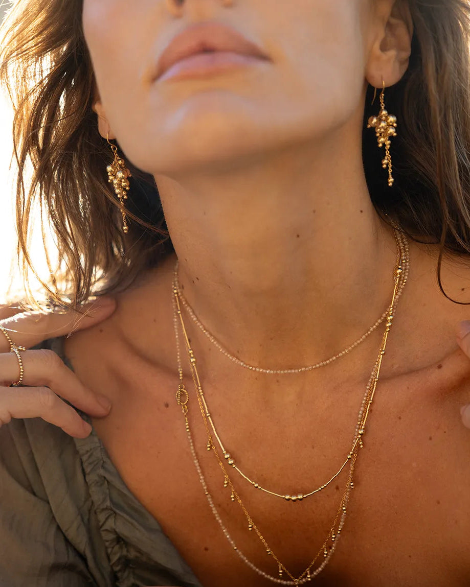 Model wearing gold beaded earrings expertly hand wire-wrapped onto a sleek, medium-weight chain