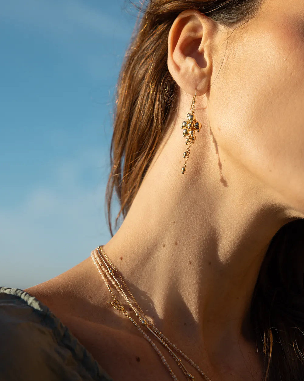 Model wearing gold beaded earrings expertly hand wire-wrapped onto a sleek, medium-weight chain