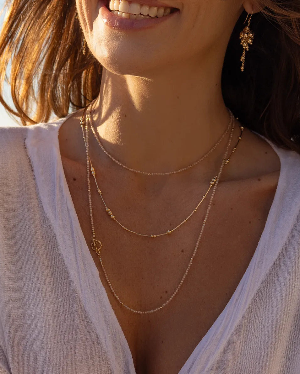 Model wearing gold beaded earrings expertly hand wire-wrapped onto a sleek, medium-weight chain