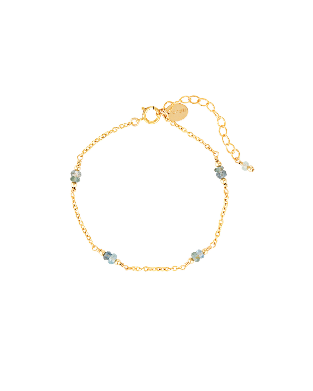 Gold chain bracelet with aquamarine gemstones on a white background