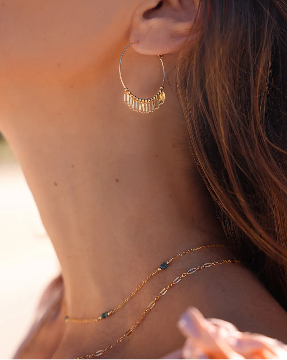 Model wearing Gold necklace wth blue raw diamond gemstones, paired with gold beads.