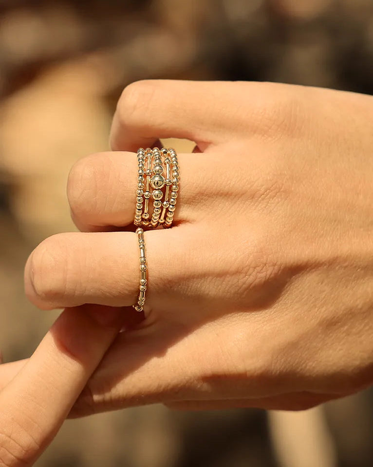 Hand wearing ring featuring a larger centre bead framed by smaller beads