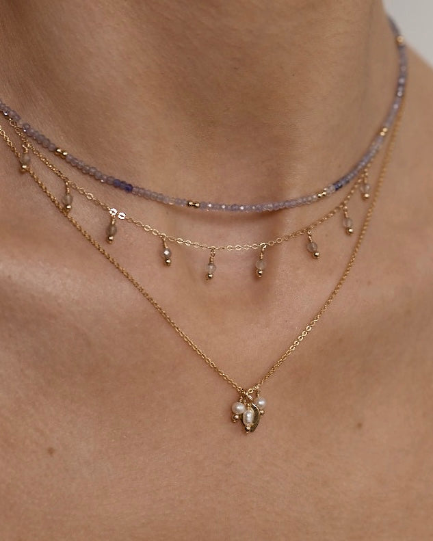 Close-up of layered necklaces on a woman's neck