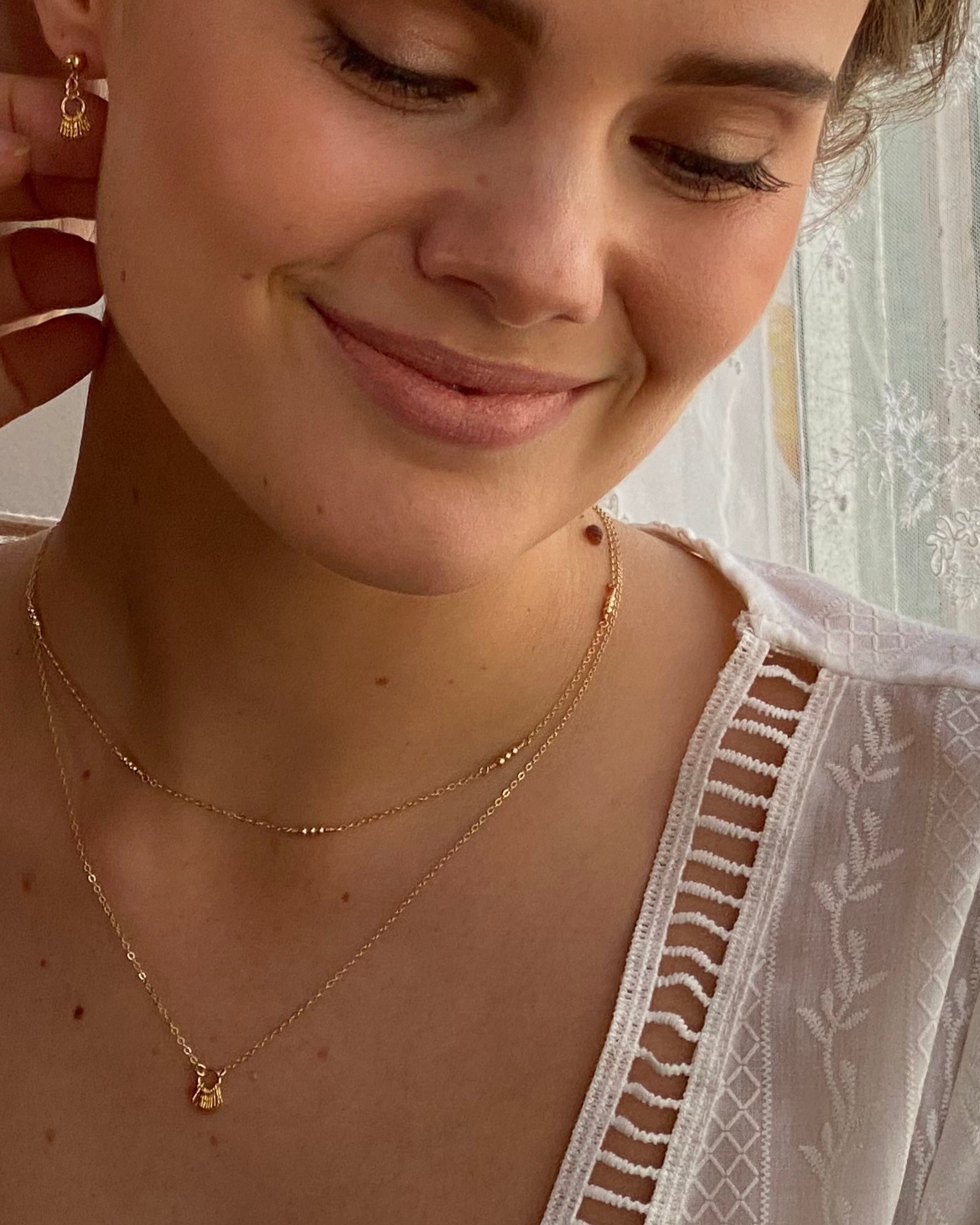 Close-up of a woman wearing gold jewelry with a blurred background