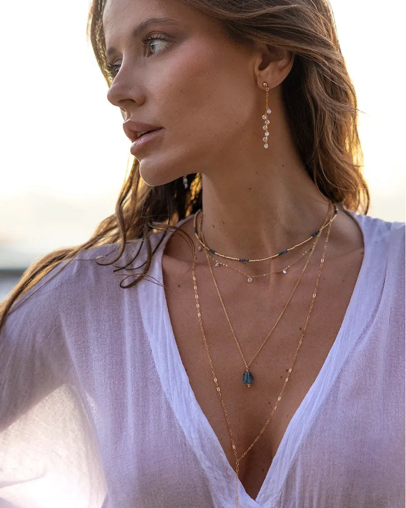 Model wearing Gold and cubic zirconia dangly earrings