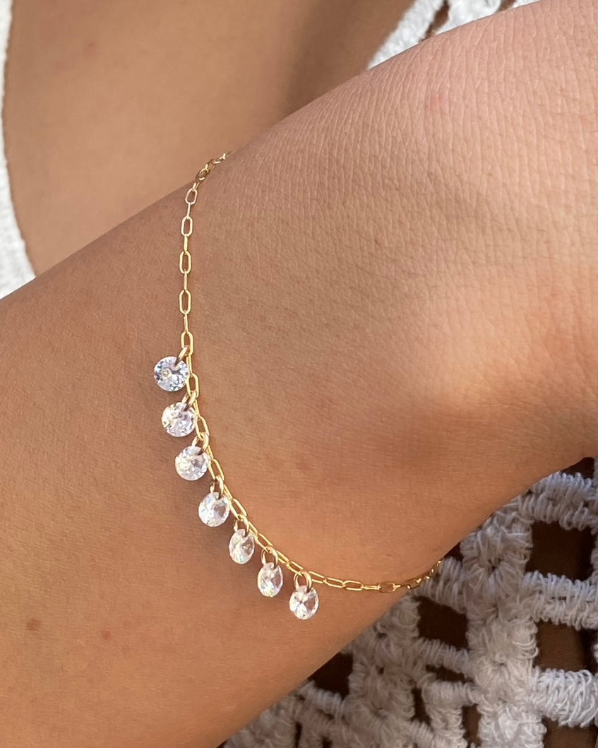 Close up of wrist wearing a delicate chain bracelet with Gold cubic zirconia gemstones 