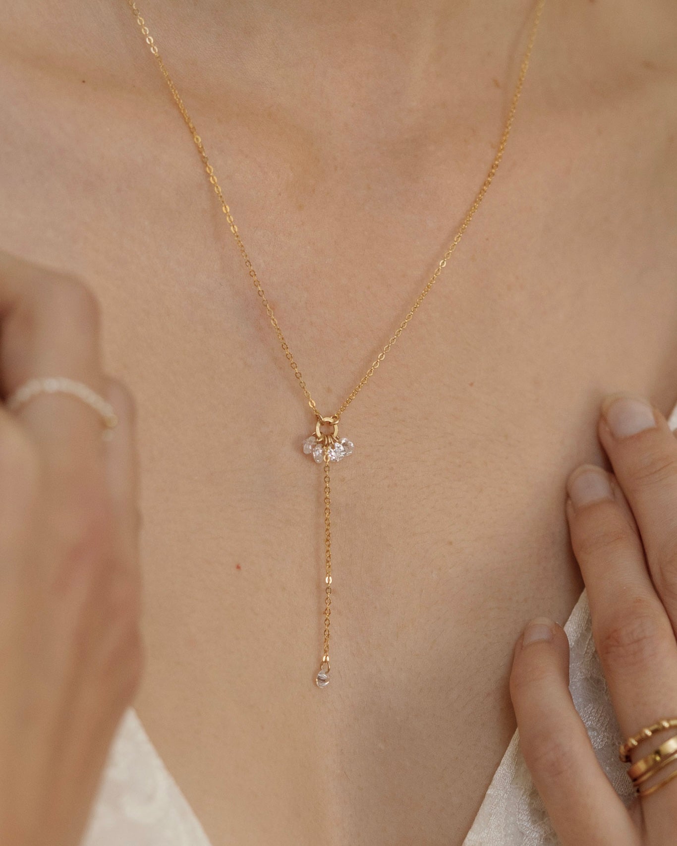 Close up of a woman wearing a delicate gold lariat cubic zirconia necklace 