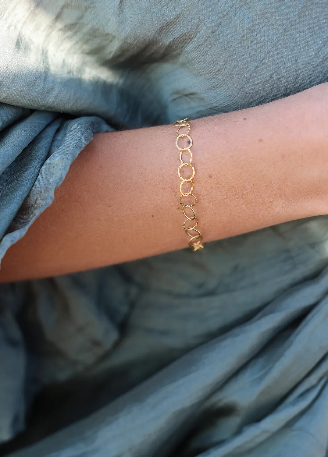 Gold chain bracelet with hammered links, finished with a luxe tassel of meticulously wire-wrapped golden beads.