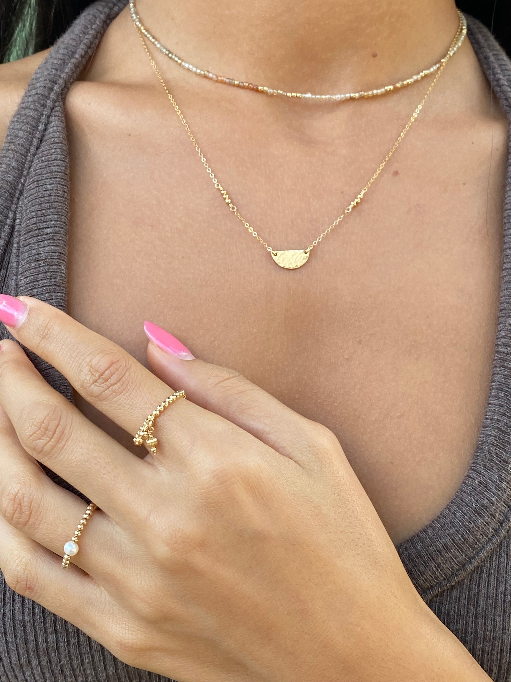 Close-up of a person wearing gold necklaces and rings