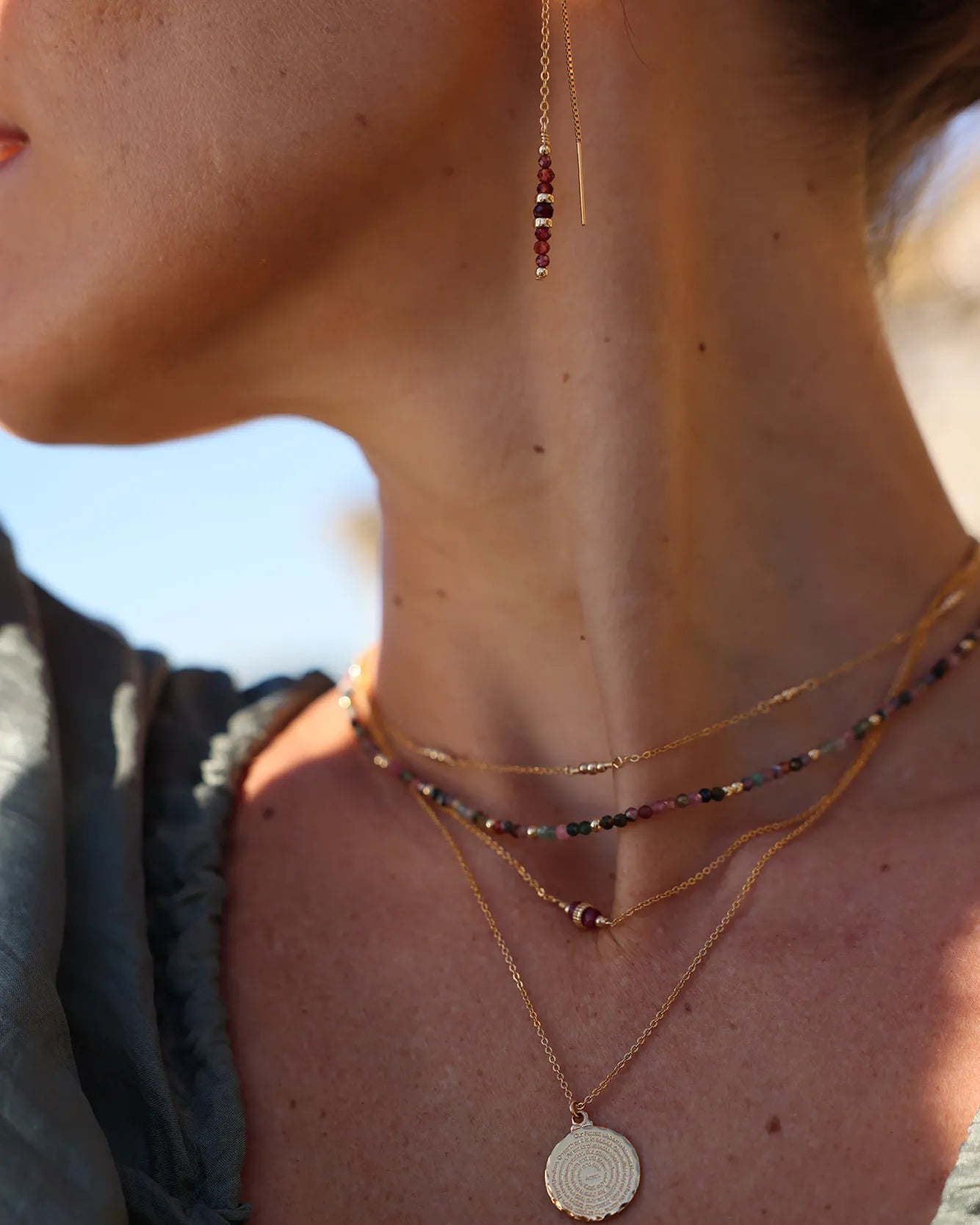 Model wearing Gold chain earrings with Garnet beads