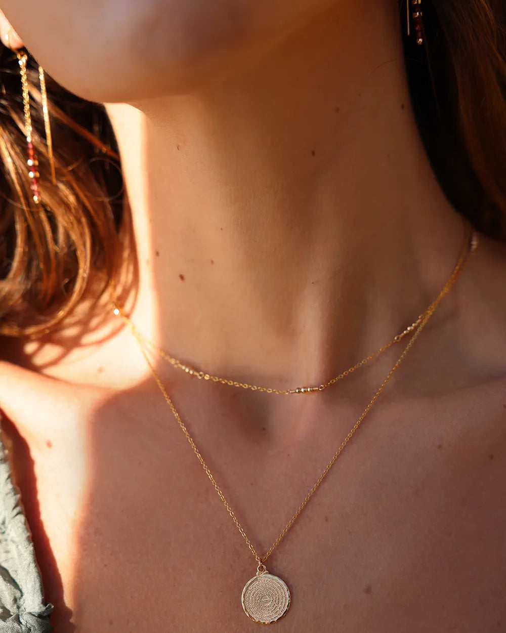 Model wearing Gold chain earrings with Garnet beads