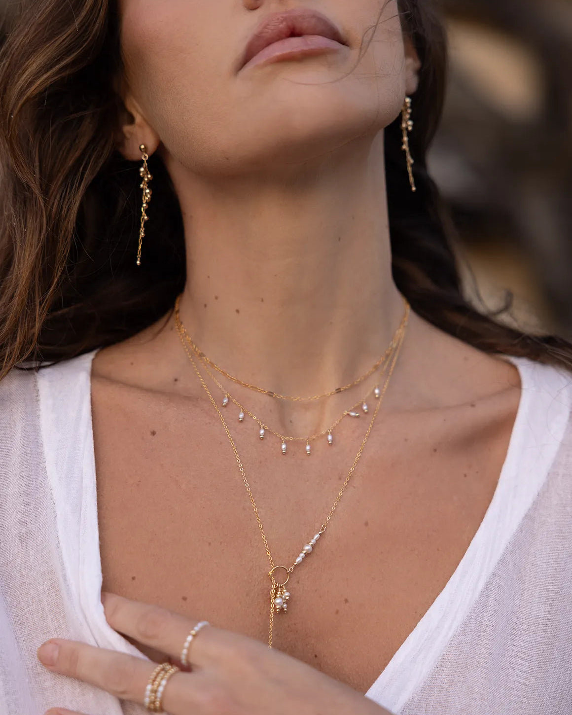 Model wearing old earrings with wire wrapped beads and suspended from a fine gold-filled chain