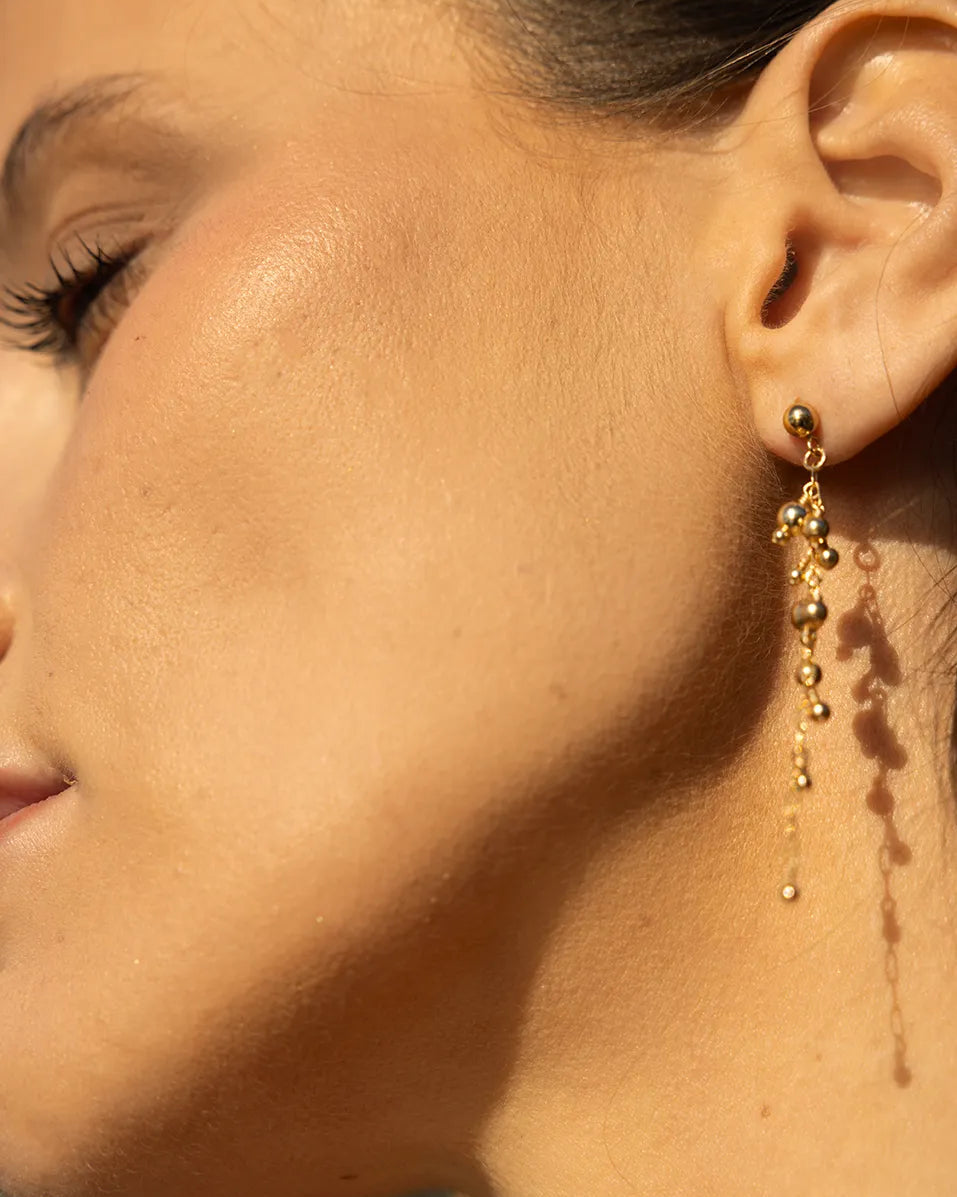 Model wearing old earrings with wire wrapped beads and suspended from a fine gold-filled chain