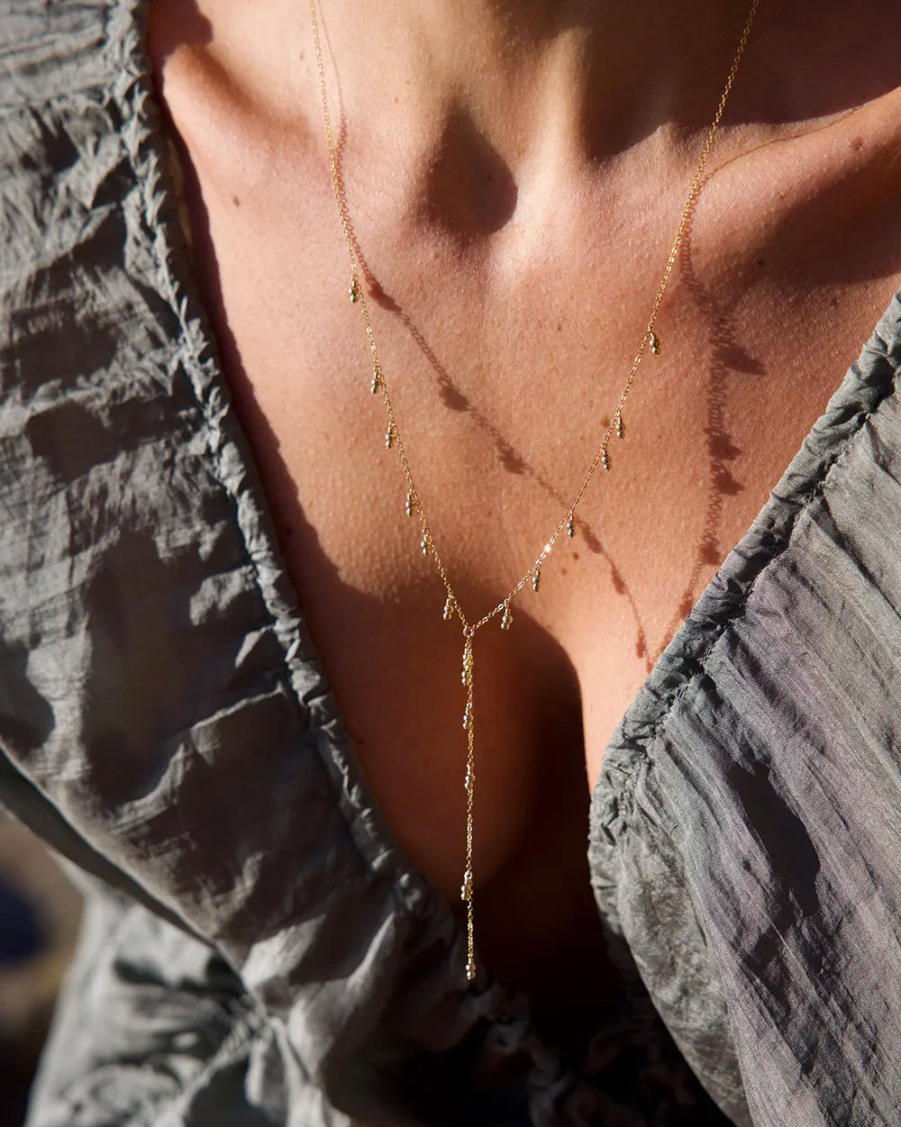 Model wearing Gold lariat necklace with Delicate gold beads