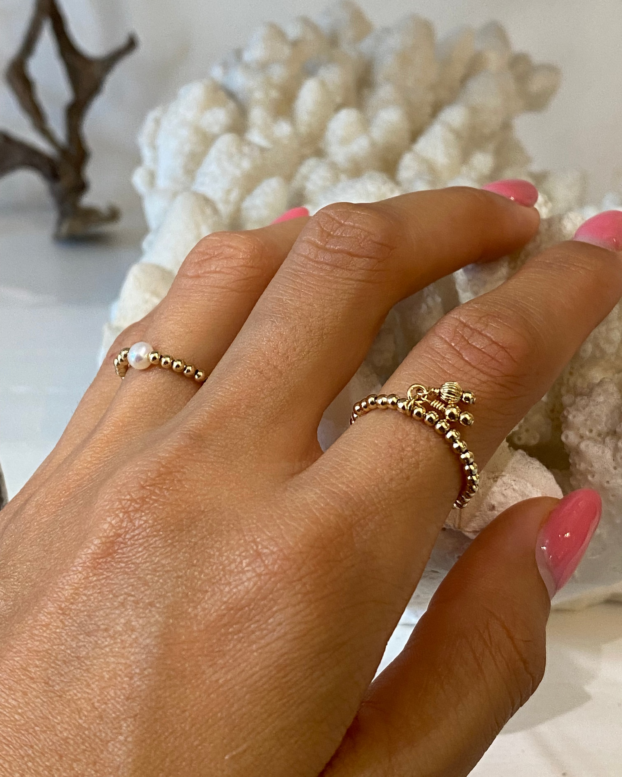 Hand wearing gold beaded rings