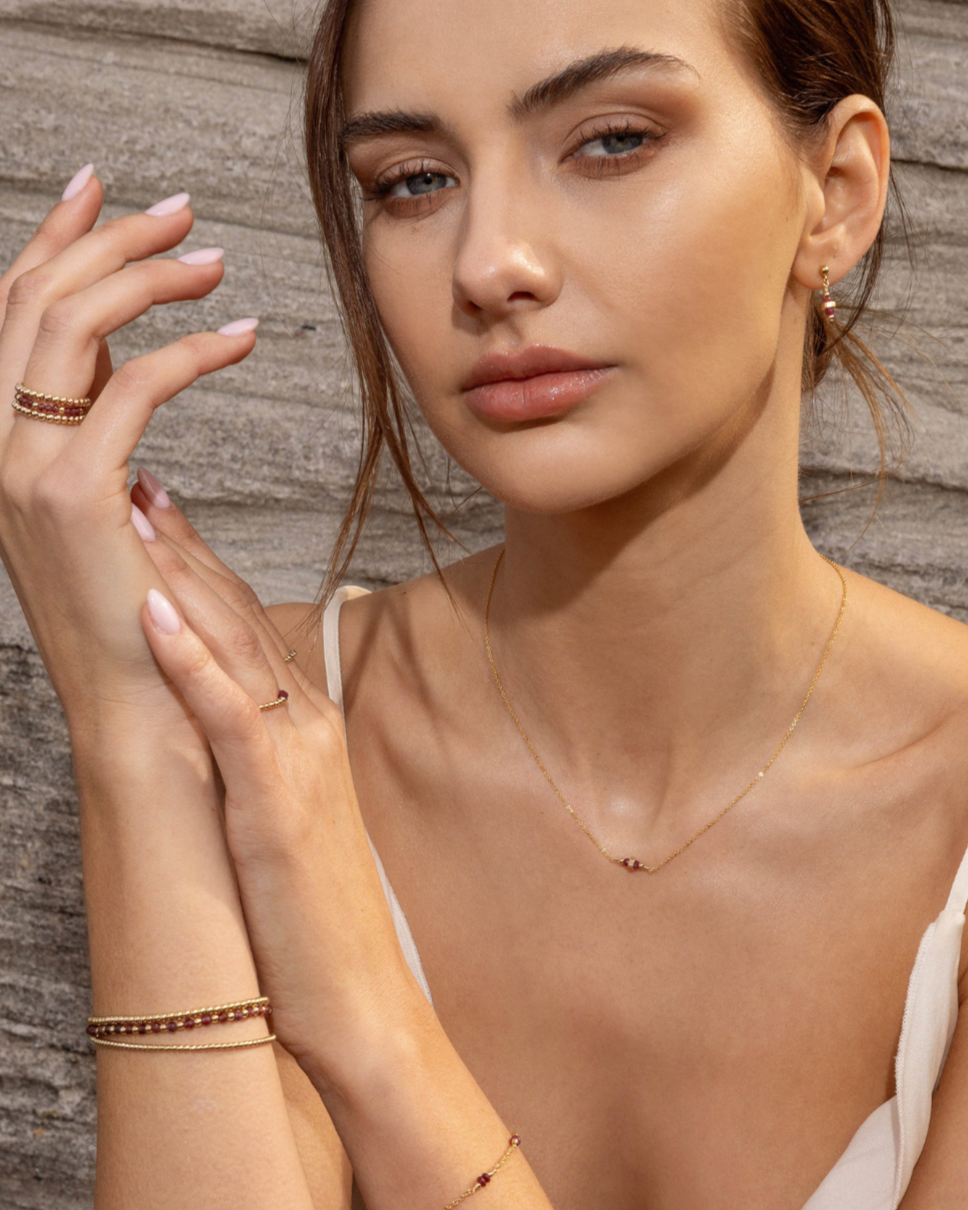Woman wearing gold and ruby gemstone jewellery