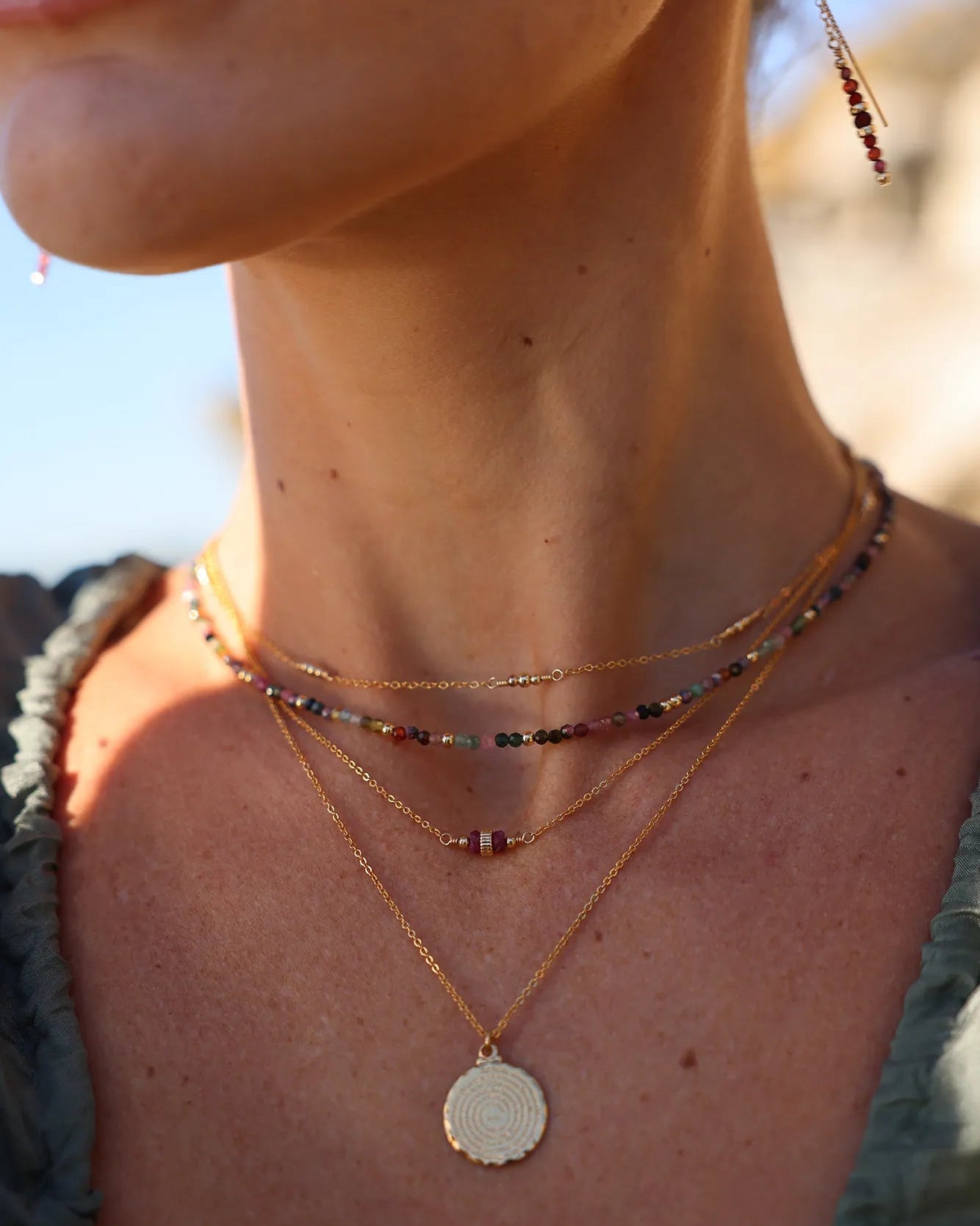 Model wearing gold and ruby gemstone necklace