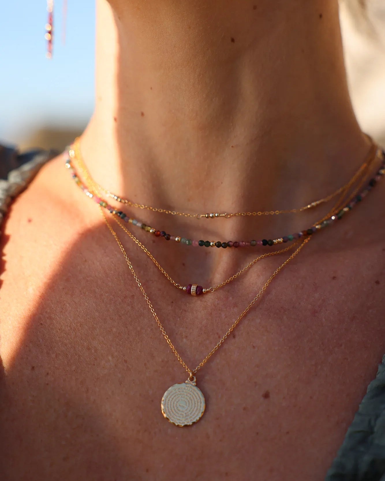 Model wearing gold and ruby gemstone necklace