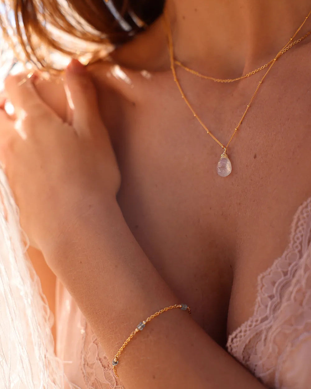 Model wearing gold necklace with delicate gold bar links