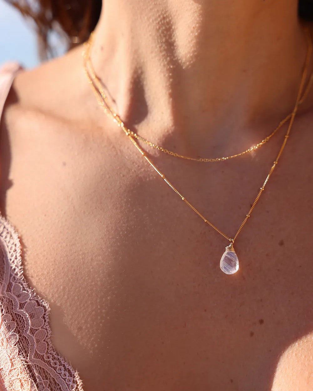 Model wearing gold necklace with delicate gold bar links