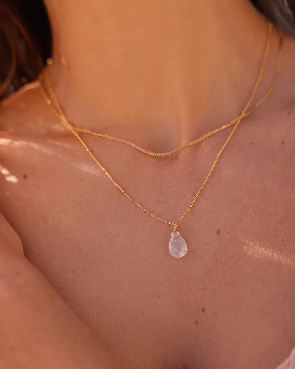 Model wearing gold necklace with delicate gold bar links